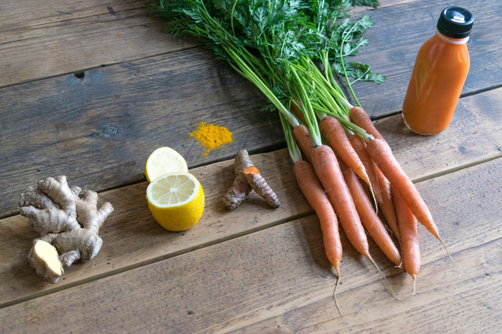 carrot and green vegetable on brown wooden table